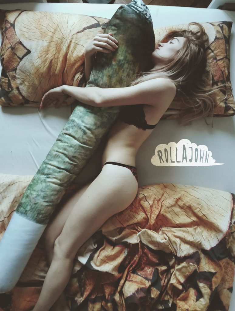 ładna dziewczyna blondynka leży an łóżku w bieliźnie i przytula się do poduszki big J body pillow